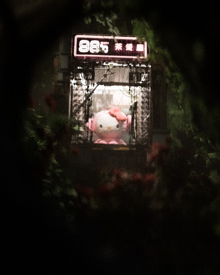 A pink neon sign on a dark street